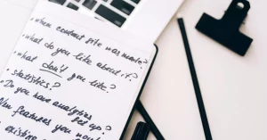 A close-up view of a notebook with handwritten notes alongside a laptop for planning and strategy.