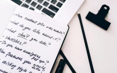 A close-up view of a notebook with handwritten notes alongside a laptop for planning and strategy.